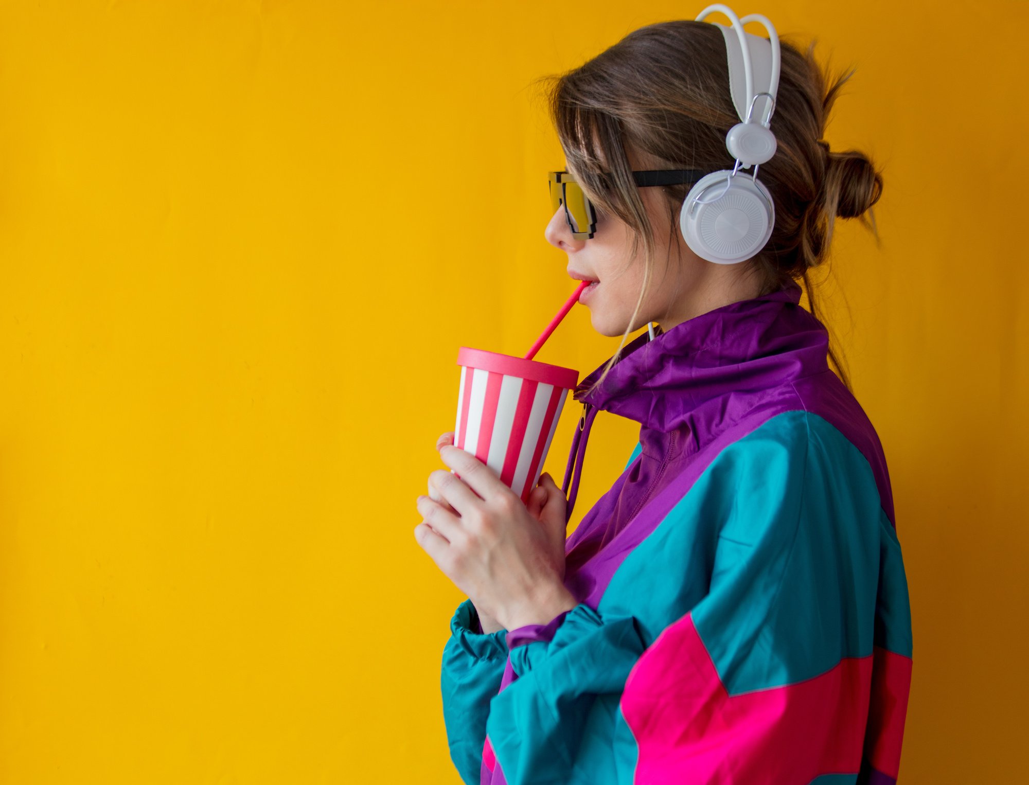 Woman in 90S Style Clothes and Headphones Drinking From Cup